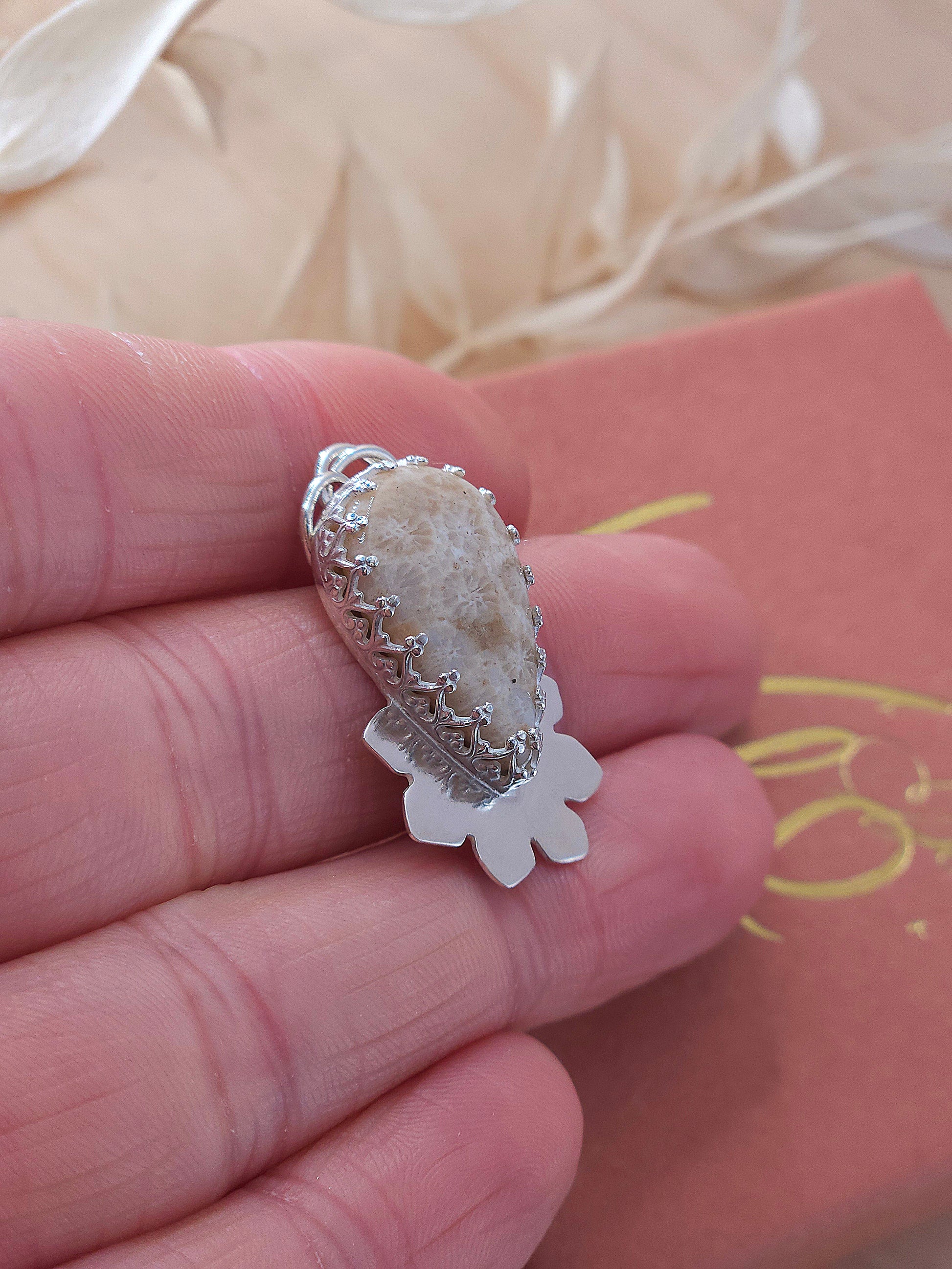 A sterling silver fossil coral necklace with a half flower design.