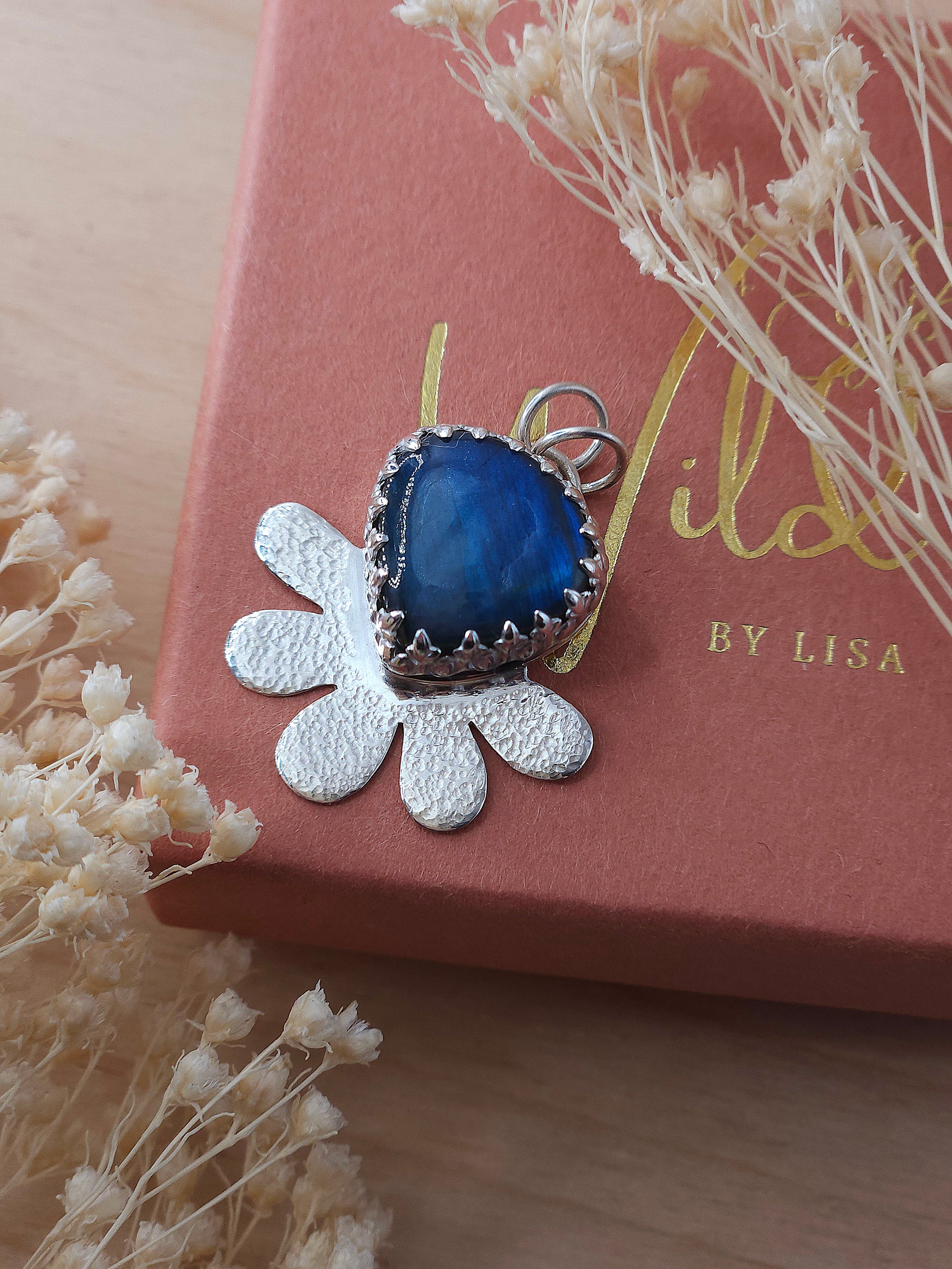 Labradorite gemstone flower pendant placed on Wild by Lisa giftbox.