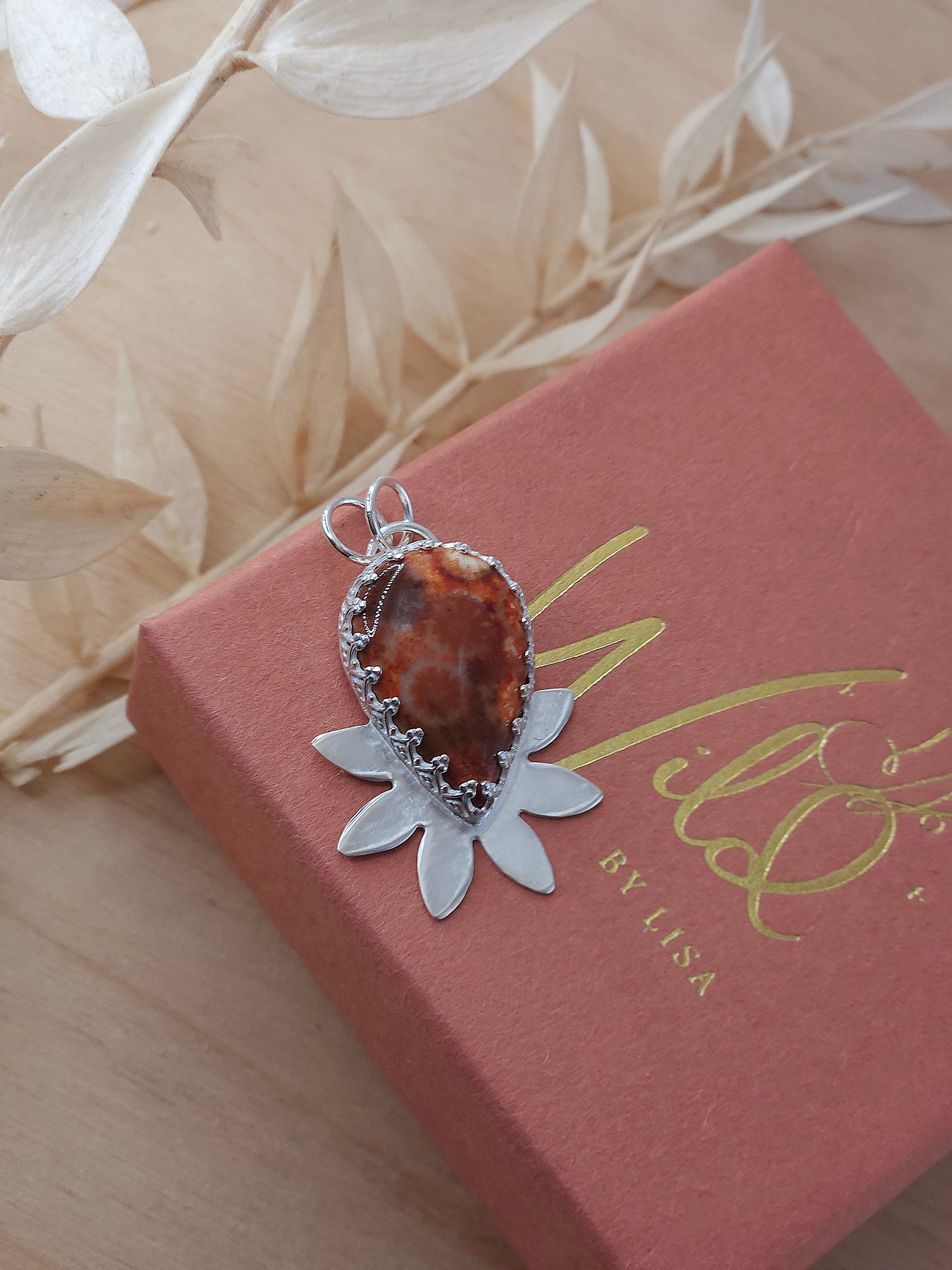 A red fossilised coral necklace with a half flower design. Handmade in sterling silver.