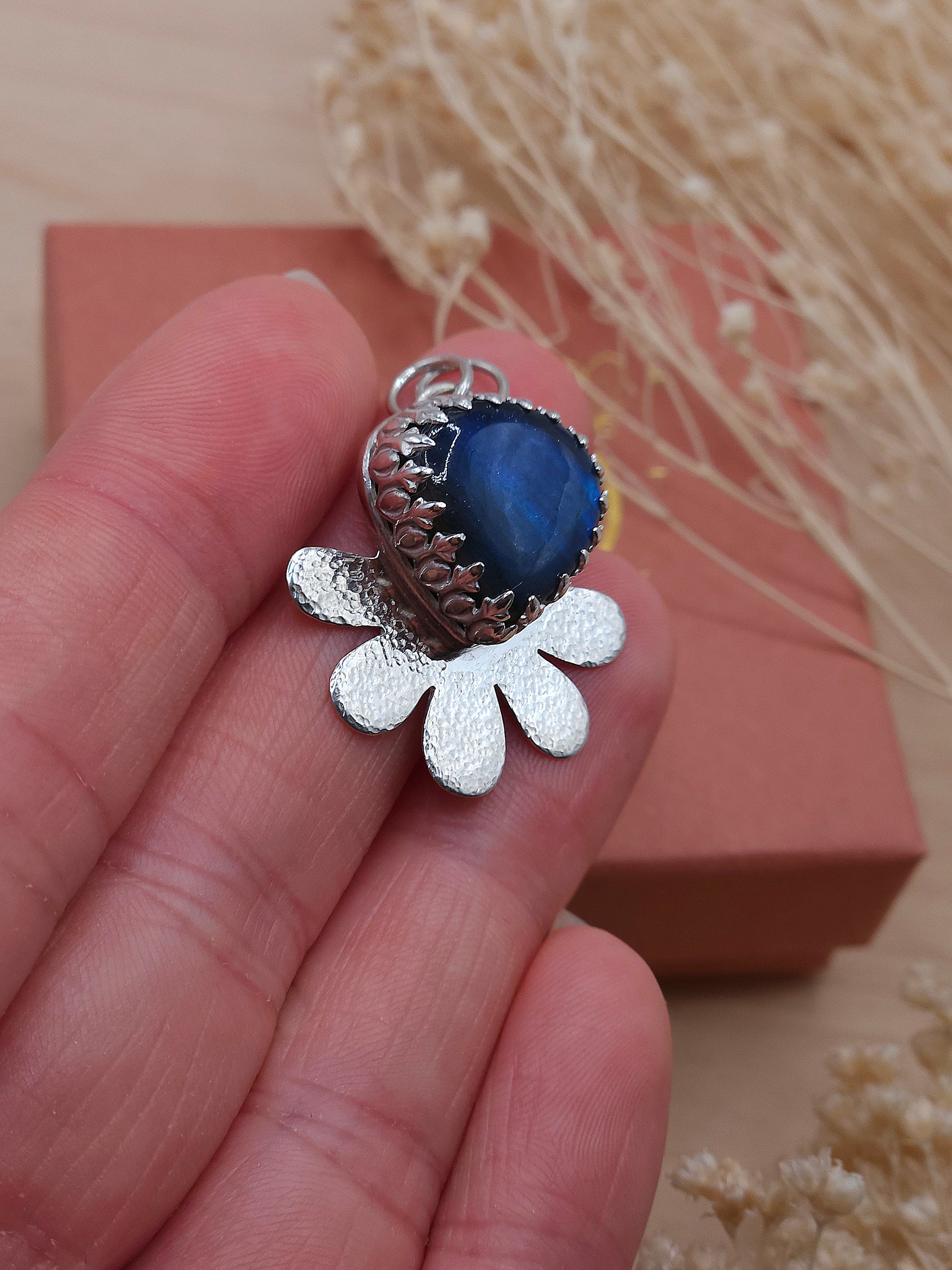 A side view of a blue Labradorite silver flower necklace.