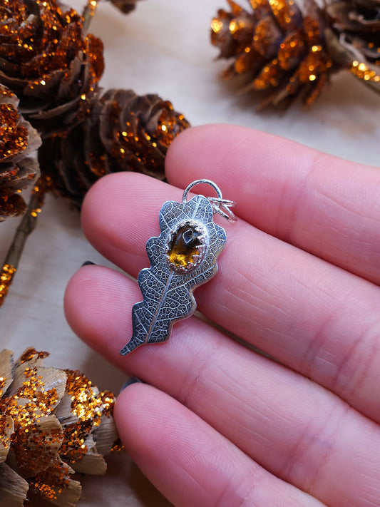 A sterling silver leaf print necklace with a brown Tourmaline gemstone.
