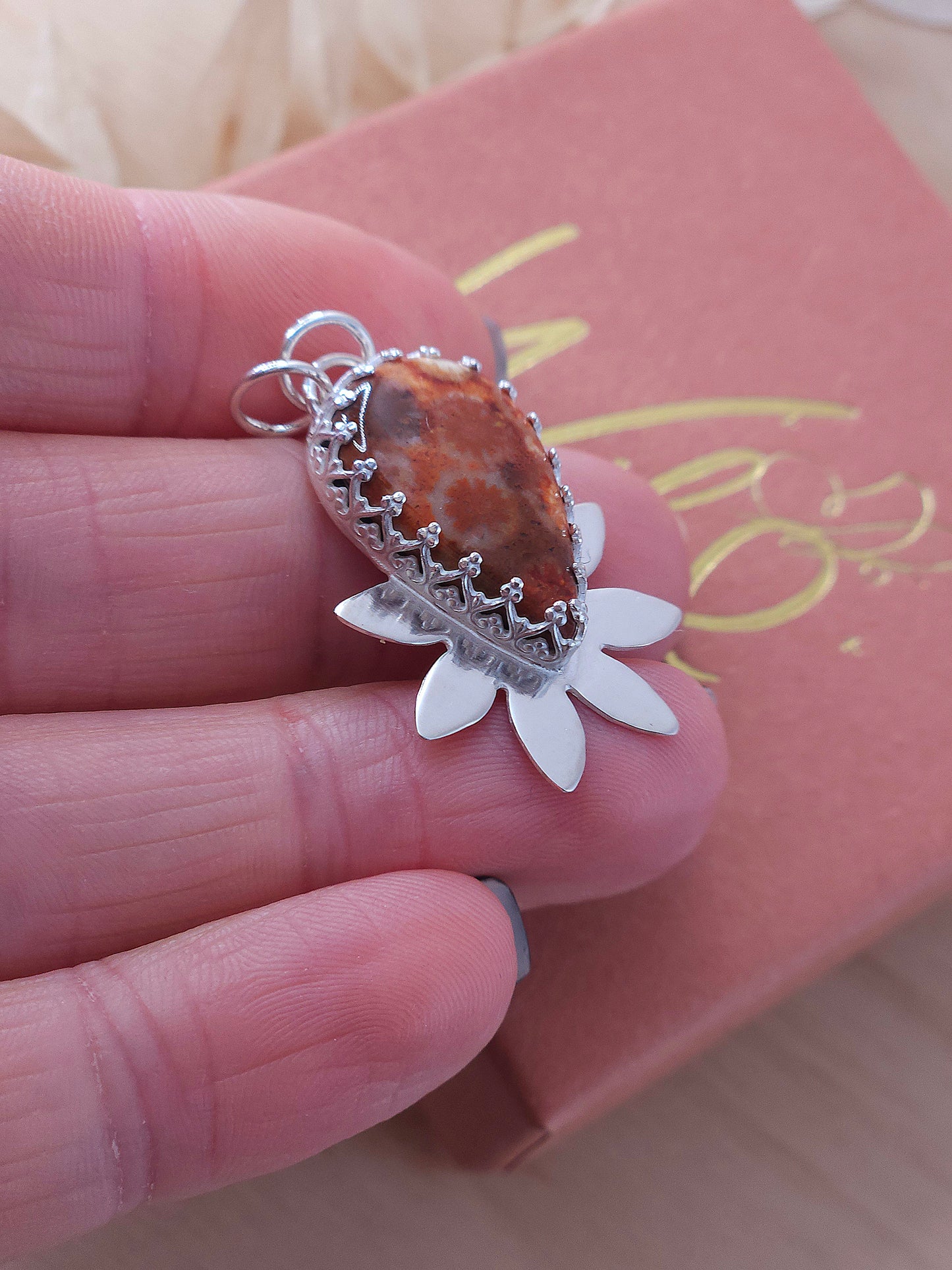 A side view of the red fossil coral flower necklace.