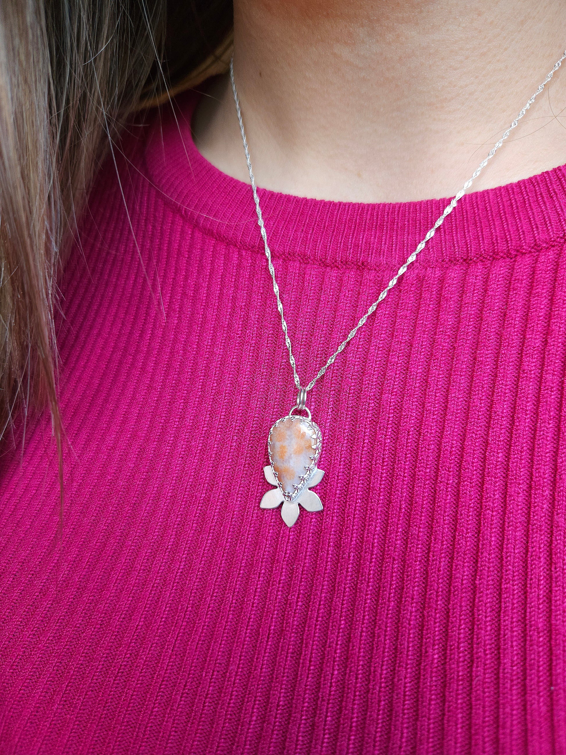 An image showing the pink fossil coral necklace being worn with the 18 inch twisted curb chain.