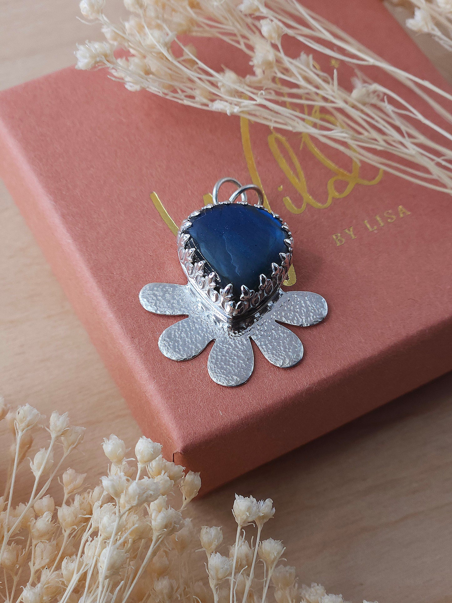 A front view of the hammered flower necklace featuring a blue Labradorite gemstone.