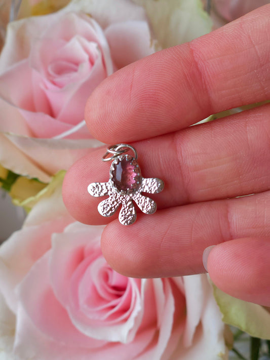A sterling silver hammered flower pendant with a pink Tourmaline gemstone.
