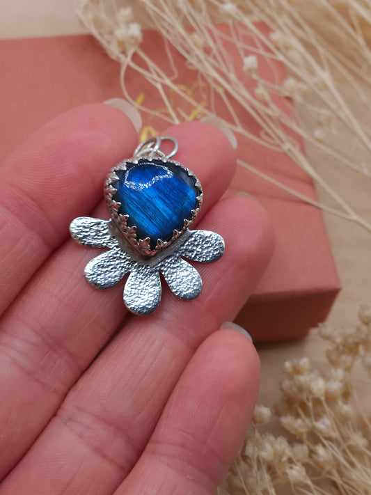 A close up of the Labradorite hammered flower pendant, showing the blue flash appearance of the gemstone.