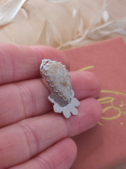 A sterling silver fossil coral necklace with a half flower design.