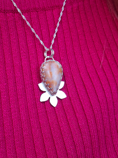 The pink fossil coral flower necklace being worn.