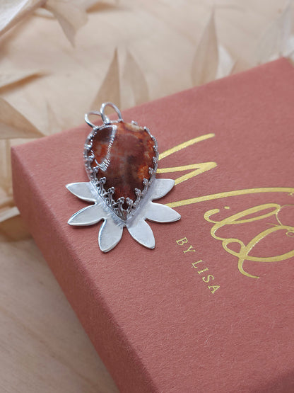 A front view of the red fossil coral necklace, showing off the silver half flower design.