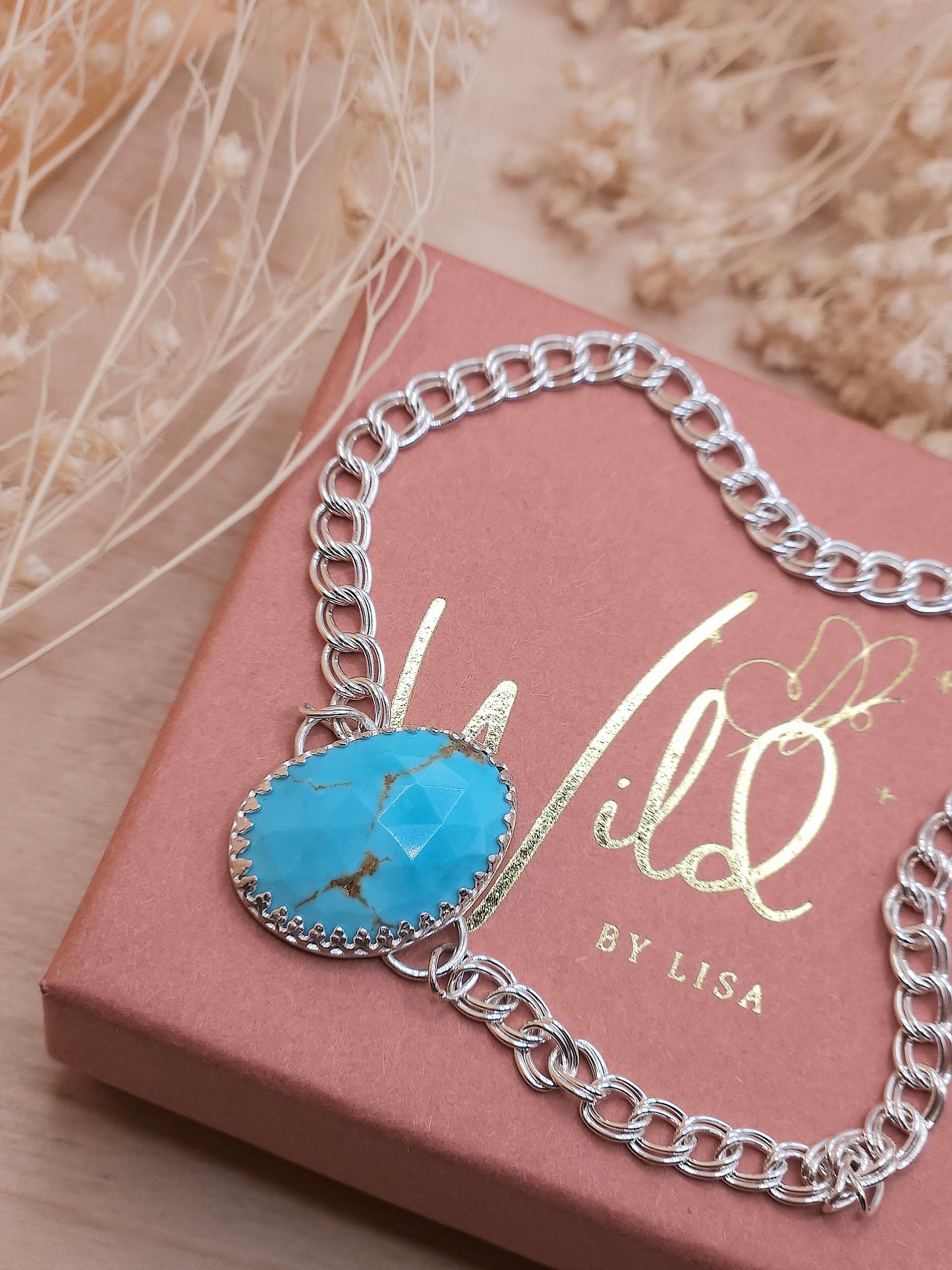 A sterling silver chain bracelet with a  golden spiderweb turquoise gemstone, displayed on a gift box with 'Wild by Lisa' branding.