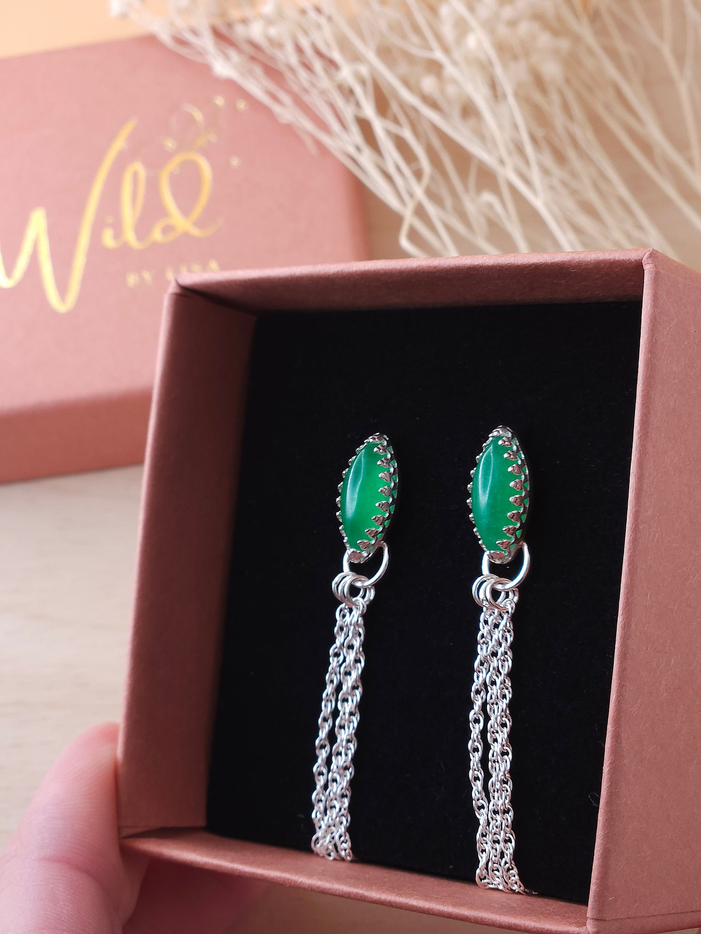 A pair of green aventurine silver dangle earrings displayed in a gift box showing the side view.