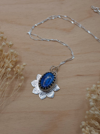 A silver flower pendant with blue Labradorite gemstone. Comes with an 18 inch sterling silver twisted curb chain.