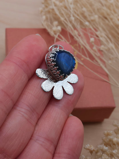 A side view of a blue Labradorite silver flower necklace.