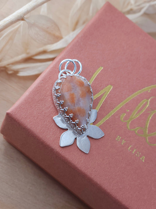 A peachy pink fossilised coral necklace with a half flower design. 
