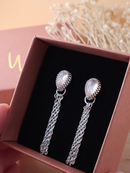 A pair of silver chain dangle earrings with rose quartz gemstones displayed in an open gift box.