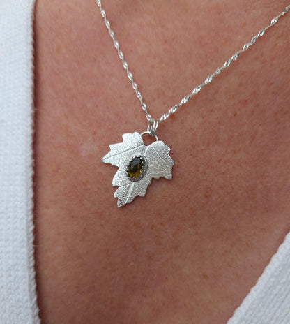 A sterling silver leaf pendant with a brown tourmaline gemstone.