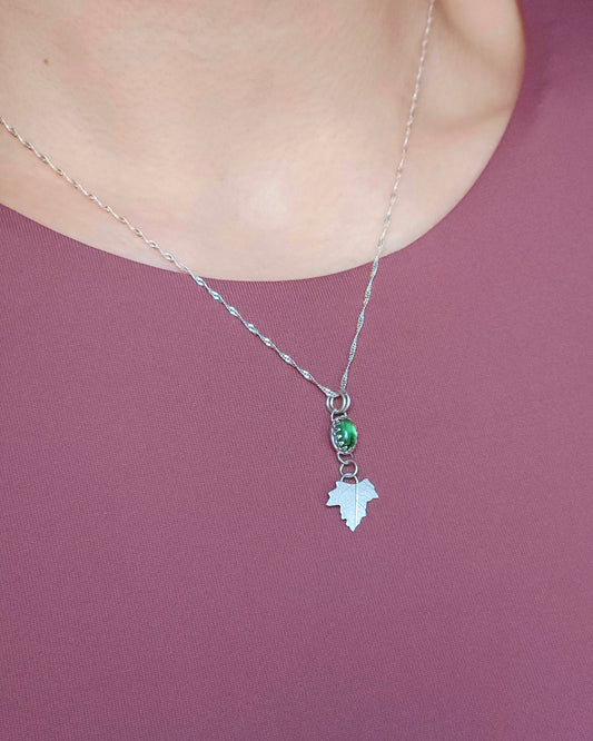 A dainty green tourmaline leaf drop pendant in sterling silver. Being worn with an 18 inch twisted curb chain.