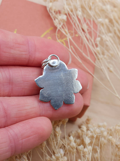 Shows the back of the flower pendant with a natural texture.